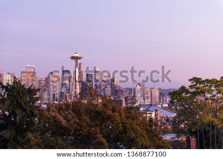Sunset over the skyline of the city of Seattle with the Space Needle, other emblematic buildings and the profile of Mount Rainier in the background, Washington, USA.