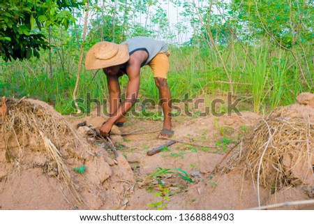 a young African man making fire on the farm