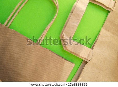 Zero waste, plastic free recycled production bag into paper bag, environmental protection concept, top view, green background, flat lay
