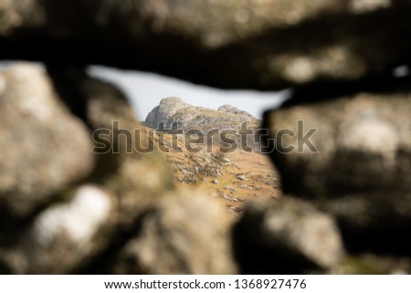 Haytor through a gap in a dry stone wall in Dartmoor National Park, Devon, South West England, United Kingdom.