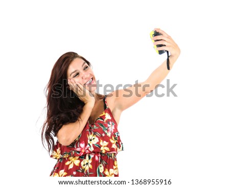 Beautiful young woman smiling while taking a photo of herself with a yellow camera against a white background