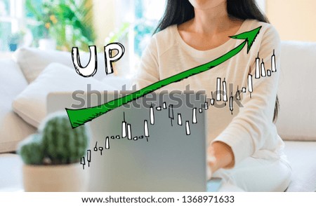Market up trend chart with woman using her laptop in her home office