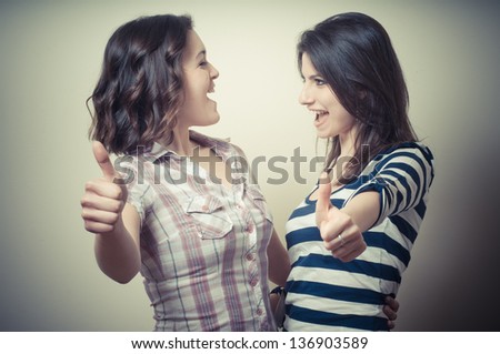 two positive young women on vignetting background