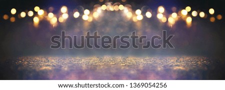 glitter vintage lights background. black, purple, blue and gold. de-focused.