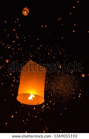 A lot of floating sky lanterns with burning paper as a tinder float to the night sky in Loy Krathong and Yi peng traditional festival
