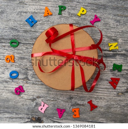  2020 Happy New year text for greeting card with craft gift box on wooden background, calendar, invitation