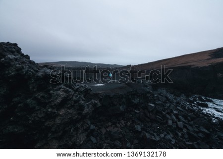Reykjanesta is located on the south-western tip of the Reykjanes peninsula, couple walking on black rocks.