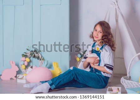 Cute girl with a bunny rabbit has easter. Beautiful happy child girl with her friend rabbit. Easter holiday concept
