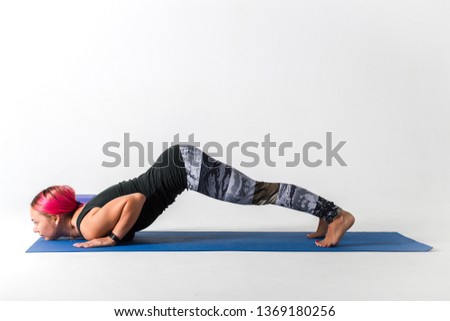 Girl doing yoga lying pose Ashtanga Namaskar on white background