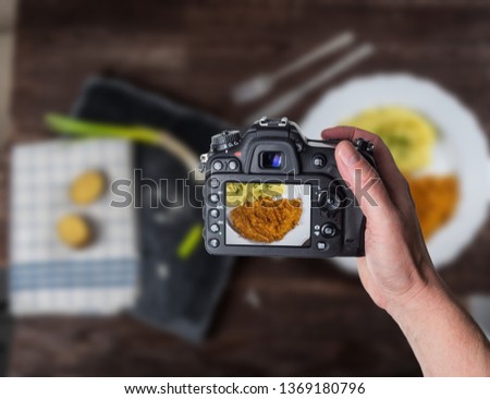 Man taking photo of Fried chicken steak or schnitzel with mashed potatoes on wood table