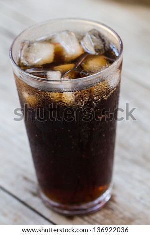 A glass of cola with ice cubes