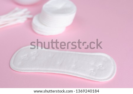 Hygiene products. Cotton pads, sanitary pads and cotton ear sticks on pastel pink background