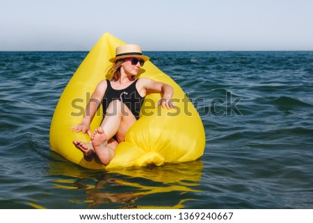 Summer Vacation. Happy young woman in bikini with rubber inflatable float, playing and having fun on a summer hot day at the sea