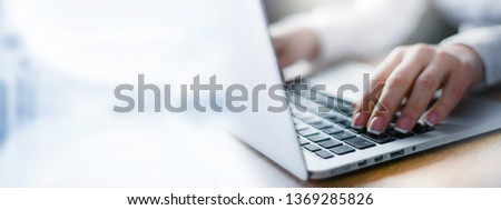 Business woman working on modern computer banner or panorama. Person buying online at internet. Laptop focused on keyboard detail with blur hand. copy space for text.