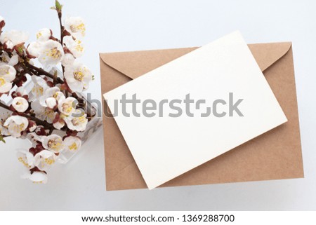 Minimalistic card mockup with cherry branch, flower, craft envelope, blossom, flat lay, top view