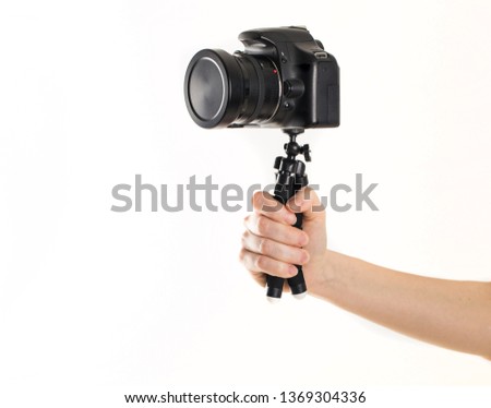 Woman hand and Black DSLR Camera on tripod isolated on white background