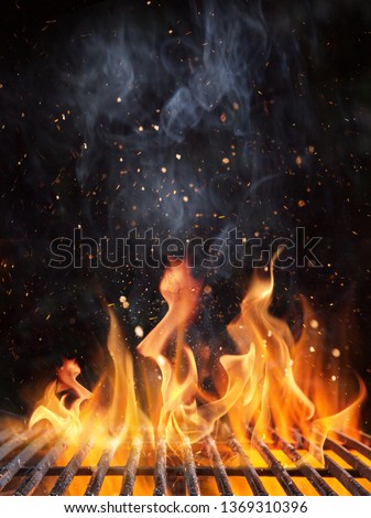 Empty flaming charcoal grill with open fire, ready for product placement. Royalty-Free Stock Photo #1369310396