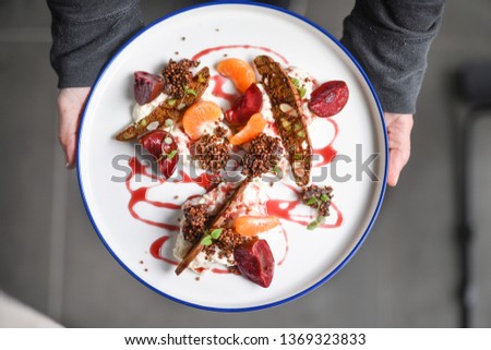 Deconstructed rice pudding with mandarin and poached plums Royalty-Free Stock Photo #1369323833