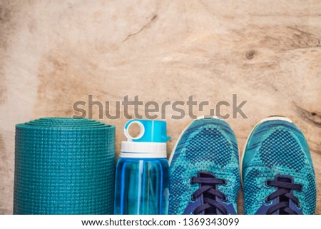 Everything for sports turquoise, blue shades on a wooden background. Yoga mat, sport shoes sportswear and bottle of water. Concept healthy lifestyle, sport and diet. Sport equipment. Copy space