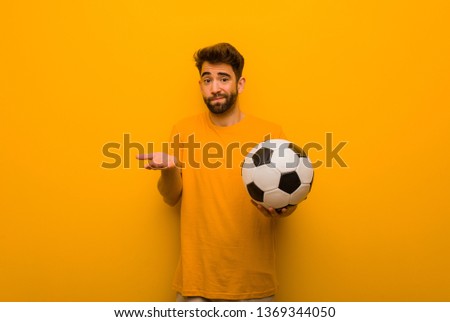 Young soccer player man confused and doubtful