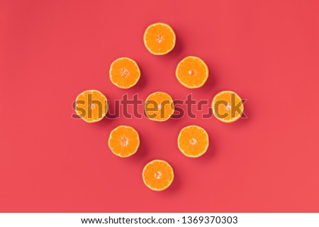 Fruit pattern of fresh orange tangerine or mandarin on living coral background. Flat lay, top view. Pop art design, creative summer concept. Citrus in minimal style.
