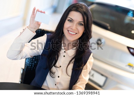 Portrait of stylish insurance agent holding a card