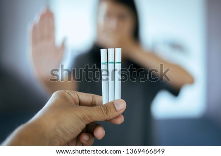Picture of cigarette with blurred woman showing hands stop,Concept no smoking day world quitting world no tobacco in 31 may day