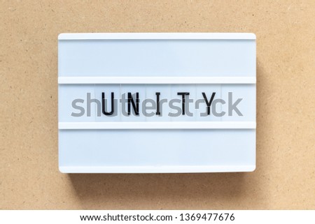 White lightbox with word unity on wood background