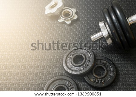 Iron dumbbells or weights on black floor with copy space for text. Health care concept. 