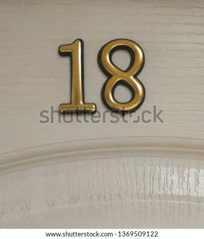  fragment of the white door of the room with voluminous numbers 18 background