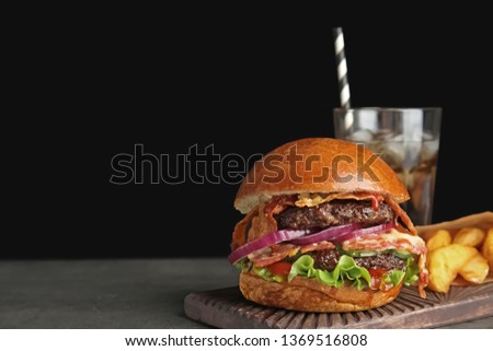 Tasty burger with bacon and fried potatoes served on table. Space for text