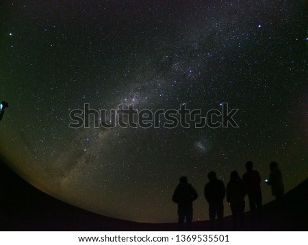Friends are standing against the background of a picturesque starry sky.