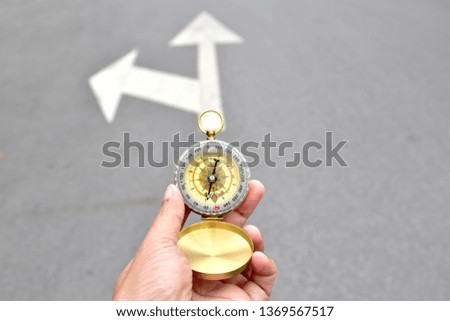 Hipster traveler holding compass in the hand making choice in what direction to go. Selective Focus.