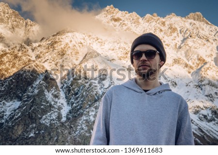 Adventurous man is standing on top of the mountain and enjoying the beautiful view during a vibrant sunset. Beautiful Nature Georgia natural landscape