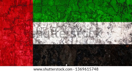 National flag of United Arab Emirates on the background of the old wall covered with peeling paint. Concept of country, nation and patriotism symbol