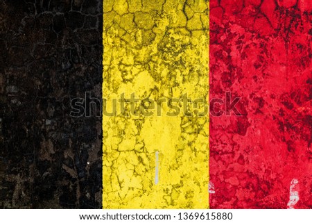 National flag of Belgium on the background of the old wall covered with peeling paint. Concept of country, nation and patriotism symbol
