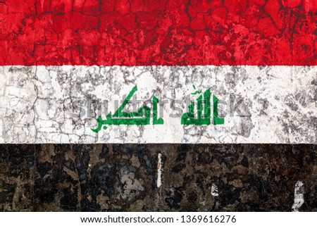 National flag of Iraq on the background of the old wall covered with peeling paint. Concept of country, nation and patriotism symbol