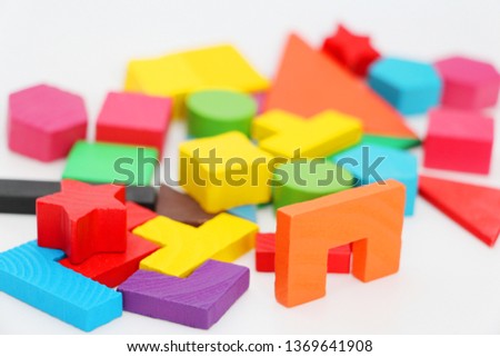 Multi-colored cubes and figures with numbers laid out randomly on a white background. Children learn to design from colored cubes. Wooden toys for children.