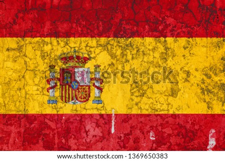 National flag of Spain on the background of the old wall covered with peeling paint. Concept of country, nation and patriotism symbol