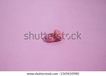 Macaroons on a colored background, picture of colorful french macarons cookies. Macaron French pastry on a pink background, minimal concept.