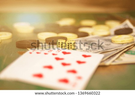 Playing cards, dice, chips and money are on the casino gambling table