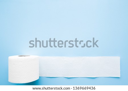 Soft, white toilet paper roll on light pastel blue background. Hygiene concept. Empty place for text, object or logo. Royalty-Free Stock Photo #1369669436