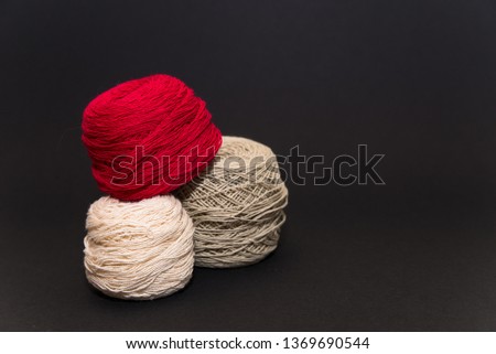 colored knitting yarn and hooks on a black background with space for text