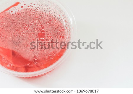 Transparent plastic container with red ginger isolated on white background