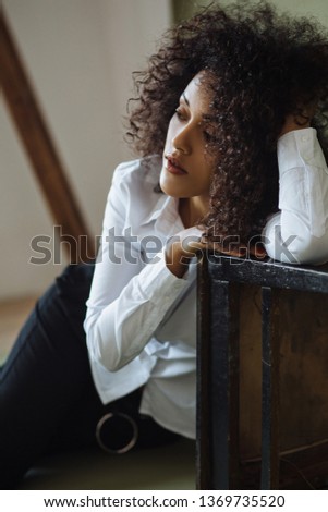 Fashion portrait of a young beautiful african american girl with afro. Studio shot business style