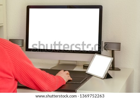 Man working on tablet and computer at the desk. Tablet and computer screen mockup. - Image