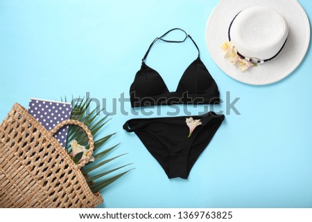 Female swimsuit with accessories on color background