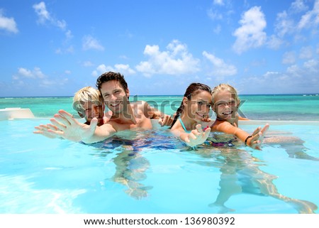 Family of four bathing in swimming pool