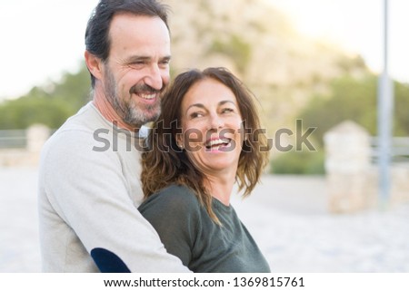 Romantic couple smiling,  cuddling and hugging on a sunny day