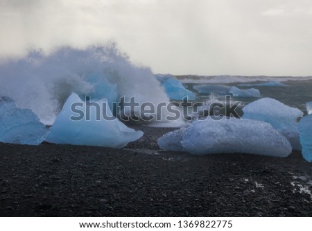 Waves crash against icebergs in Jokulsarlon in Iceland, beautiful glacial lagoon.